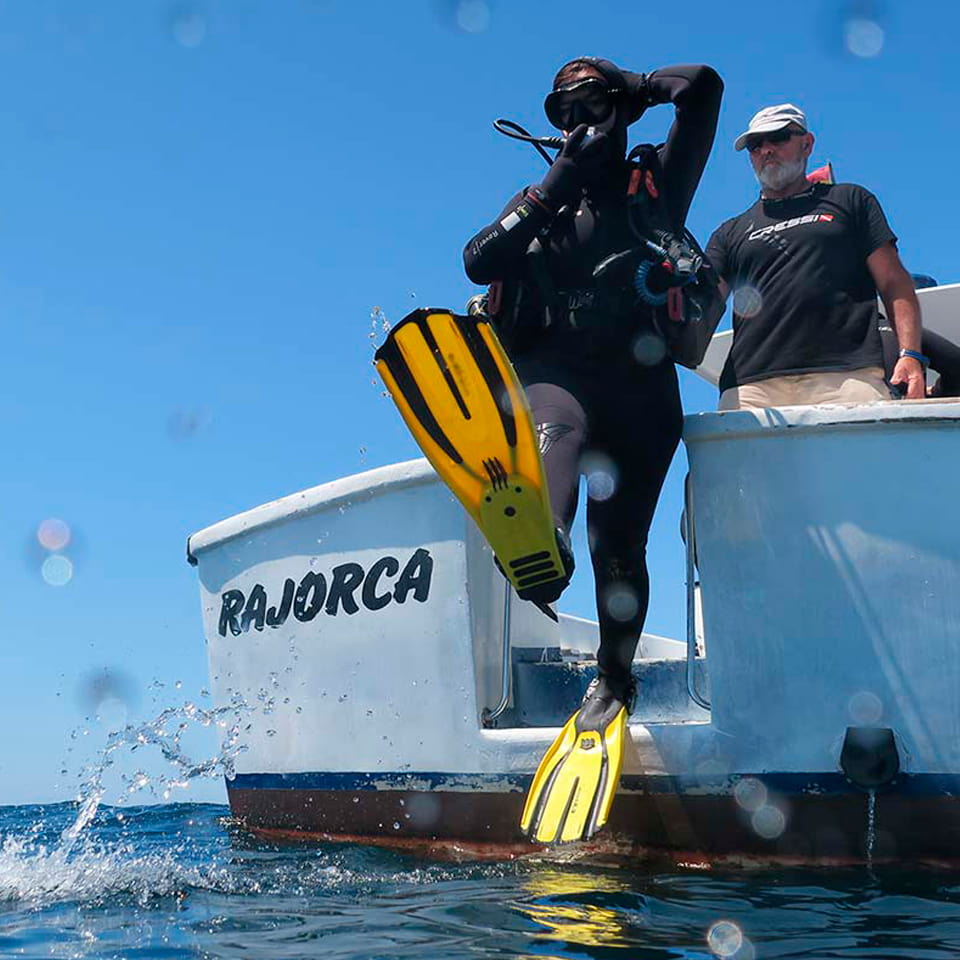 Submarinista entrando en el agua desde un barco