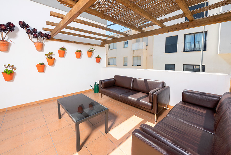 Terraza superior Tarifa Kite Hostel con sillones y plantas
