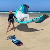 Chica con neopreno, arnés, kite tabla y barra en la playa de Tarifa