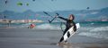 Kitesurfer saliendo del mar en Tarifa con la cometa y la tabla en la mano